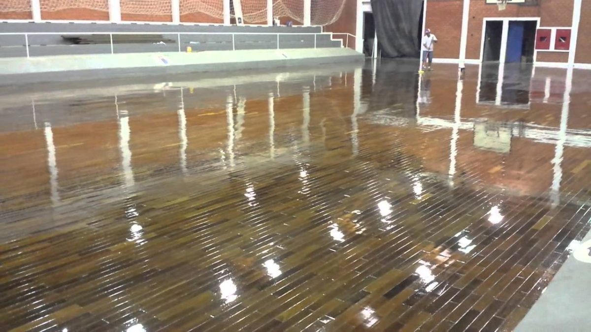Quadra esportiva com piso de madeira recém-envernizado e brilhante